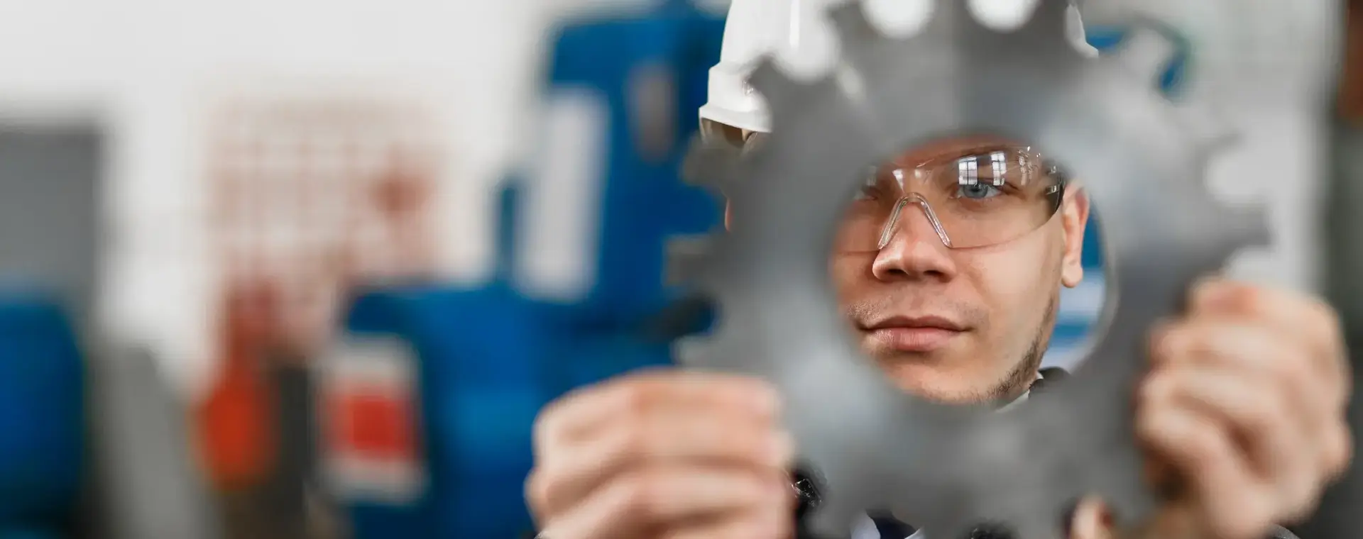 student met helm op kijkt door tandwiel