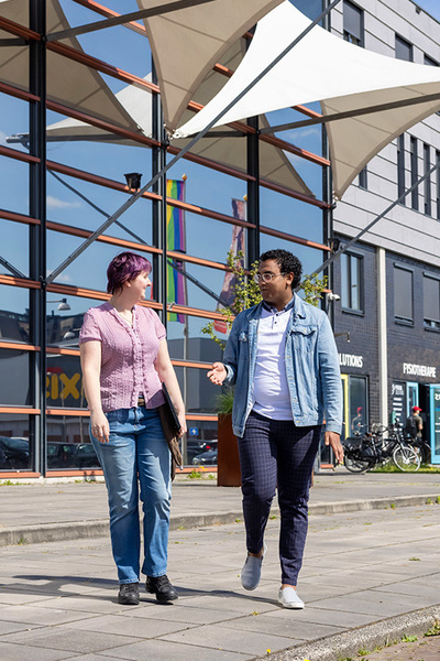 Leerlingen lopen voor het gebouw van MBO College Amstelland