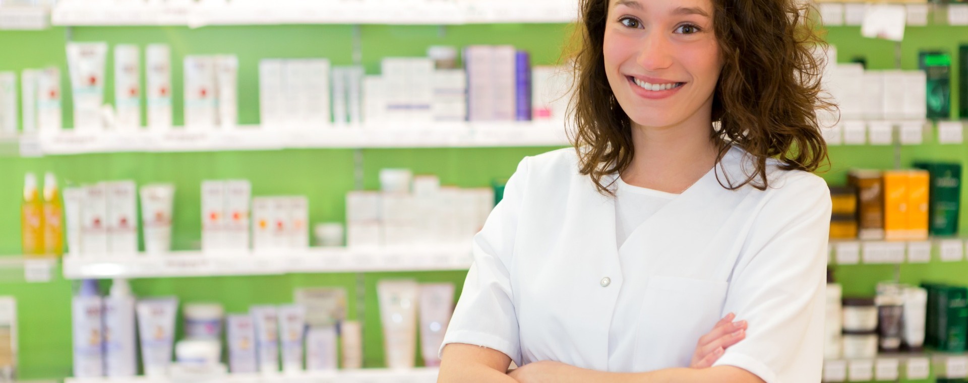 apothekersassistent in witte jas bij medicijnkast
